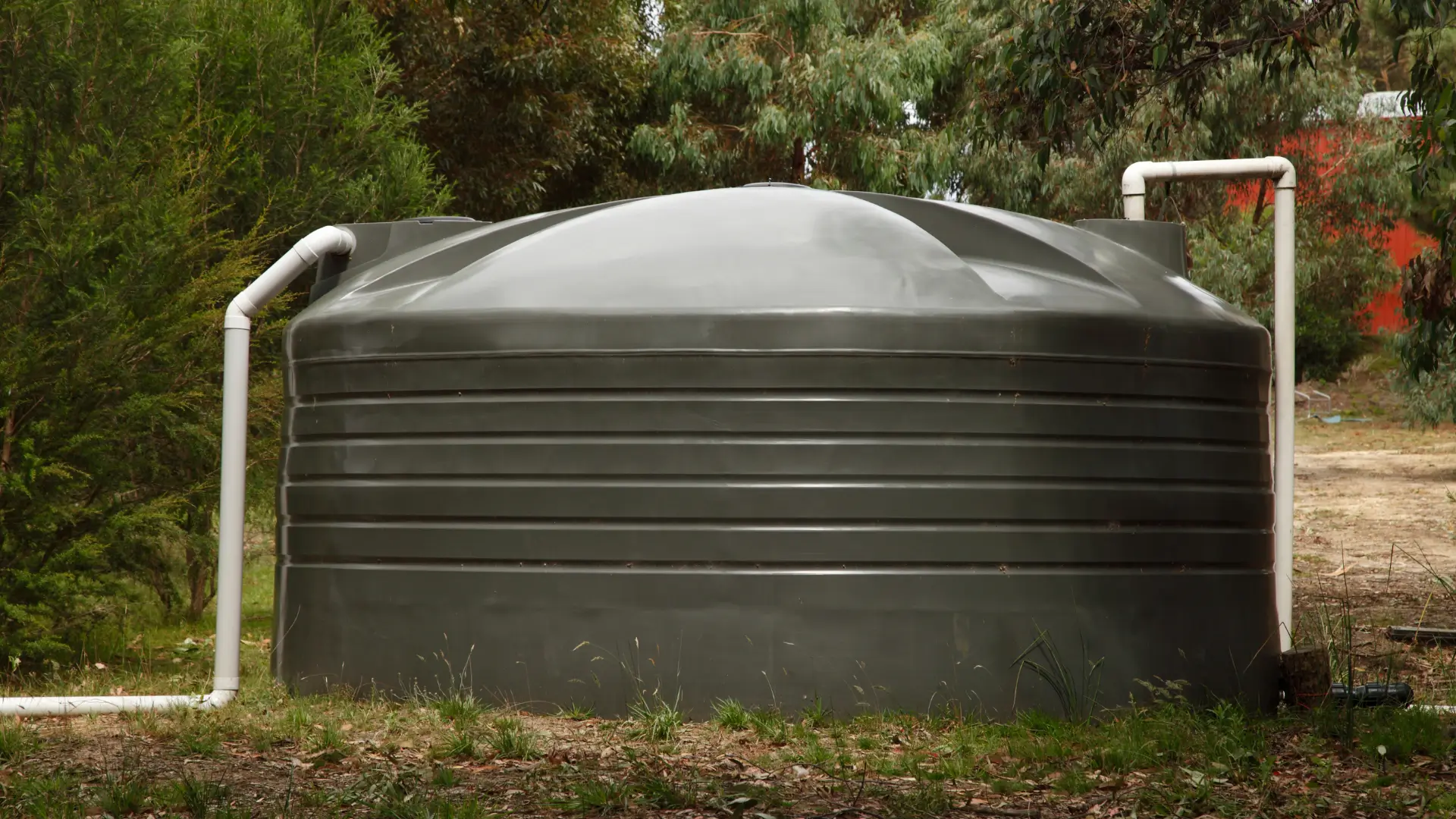 Discover Our Water Tank Installation Company South Auckland For Delivering Quality Results with a plastic water tank connected to pipes on a property.
