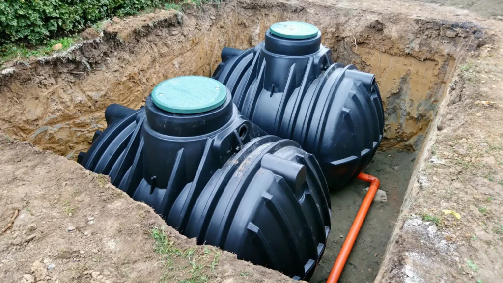 Water tank installation West Auckland showing three underground plastic water tanks in an excavation with access lids and connected pipework.
